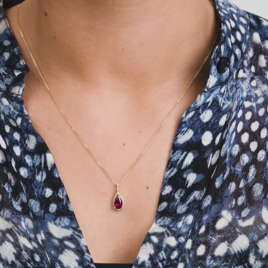 Pear Shape Created Ruby & Halo Diamond Pendant in yellow gold worn on model